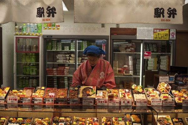 23 Dec 2017, Kyoto, Japan, Asia, A woman sells ready meals and drinks in a train station kiosk in Kyoto, Asia