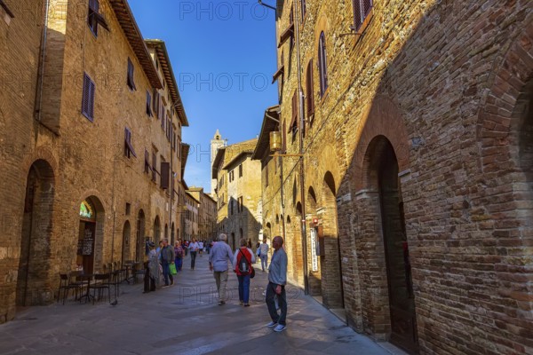 San Gimignano, Tuscany, Italy, October 25, 2018: Old medeival street and tower in typical Tuscan town, popular tourist destination, Europe