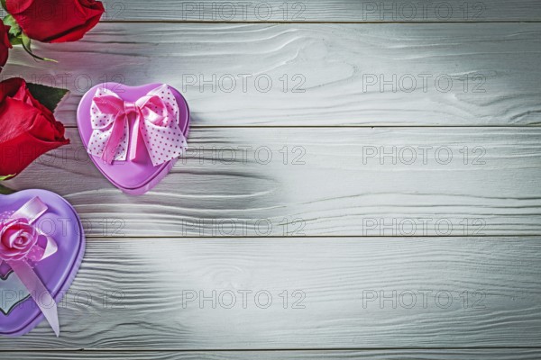Heart-shaped metal present boxes red roses on wood board holidays concept