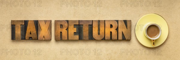 Tax return banner - word abstract in vintage letterpress printing blocks against textured paper with a cup of coffee, business financial concept