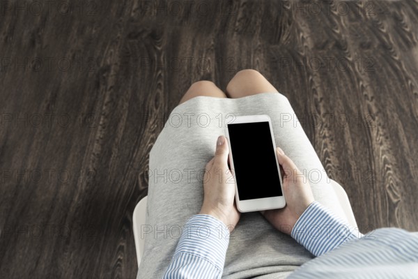 Business woman with cell phone on her lap