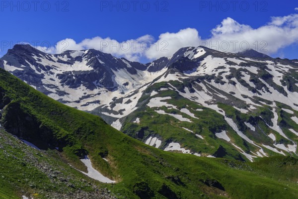 Snow-covered mountains, green slope, clear clouds and blue sky, Mittersell, Hohe Tauern, Alps, Austria, Europe