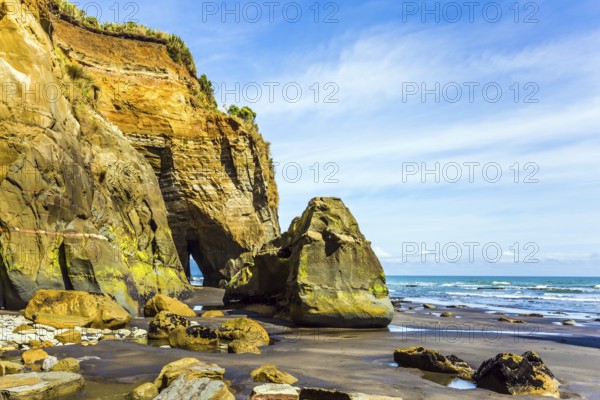 New Zealand, North Island. Powerful cliffs and arches on the Pacific coast. The concept of active and phototourism, Oceania