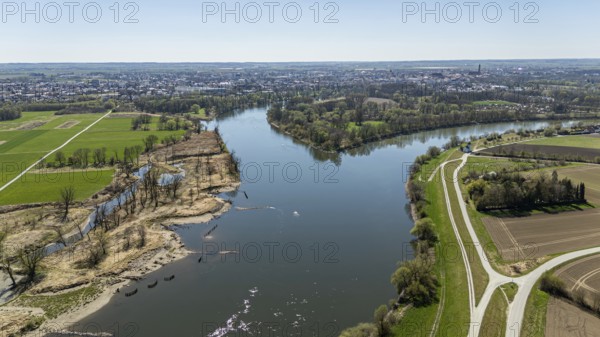 View of a river (Danube) with riverside vegetation, neighbouring fields and a town in the distance, Straubing, Lower Bavaria, drone shot
