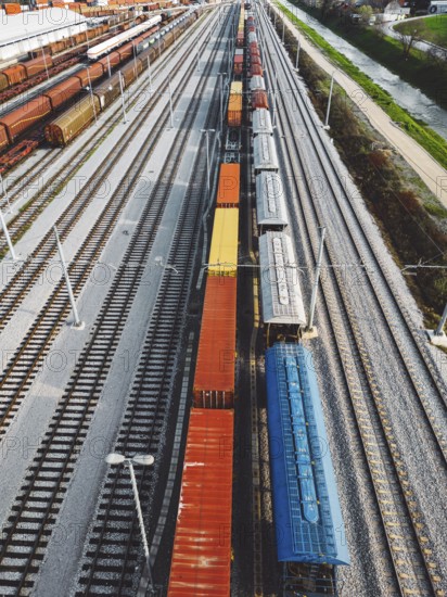 Cargo trains close-up. Aerial view of colorful freight trains on the railway station. Wagons with goods on railroad. Heavy industry. Industrial conceptual scene with trains. Top view from flying drone.