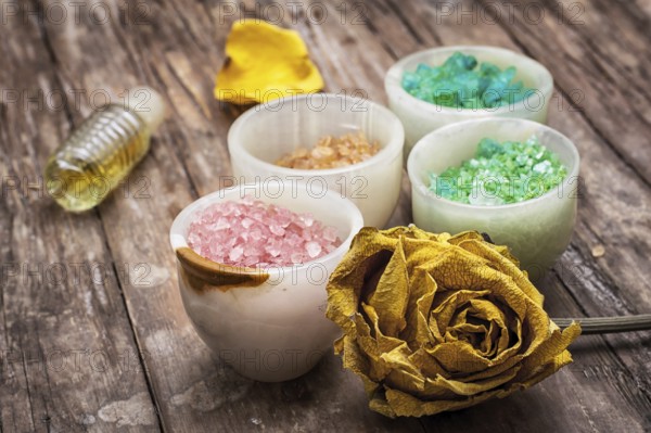 Sea aromatic salt for Spa treatments on the background of yellow rose buds