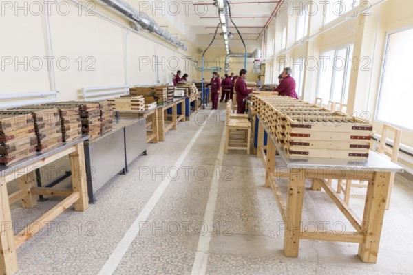 Sopot, Bulgaria - May 17, 2016: Rocket explosives for anti tank rocket-propelled grenades (rpgs, bazooka) into boxes in a munition producing factory. Workers working at the background