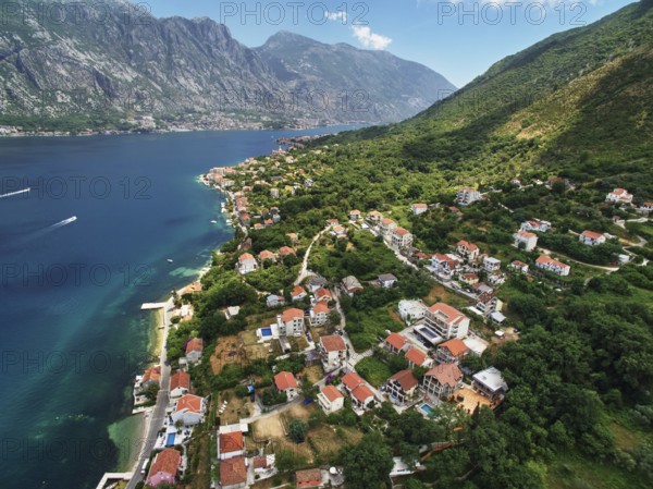 Coast of Dobrota on the shore of the Bay of Kotor at the foot of the mountains. Montenegro., Kotor Municipality, Montenegro, Europe
