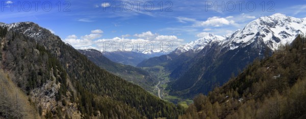 Beautiful top view panorama of high snow-covered mountains and valley with road and village in Switzerland at spring