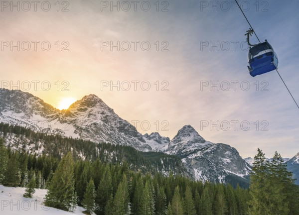 Winter landscape with evergreen fir forests, the Austrian Alps mountains and a cable car, in Ehrwald municipality, Austria, Europe
