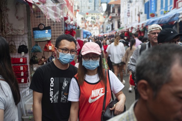 24.01.2020, Singapore, Republic of Singapore, Asia, Pedestrians wearing face masks stroll through a busy street bazaar in the Chinatown district, which takes place every year for Chinese New Year. This comes shortly after the first coronavirus infection was confirmed in the city-state, Asia