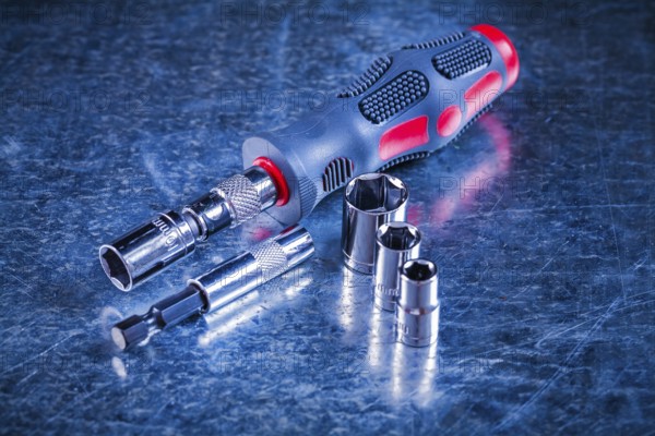 Screwdriver bit holders replaceable torxes on scratched metallic background construction concept