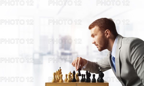 Businessman moving chess figure in chessboard. Successful management and leadership concept. Handsome man in business suit sitting at desk with chess. Operative tactics and strategy planning