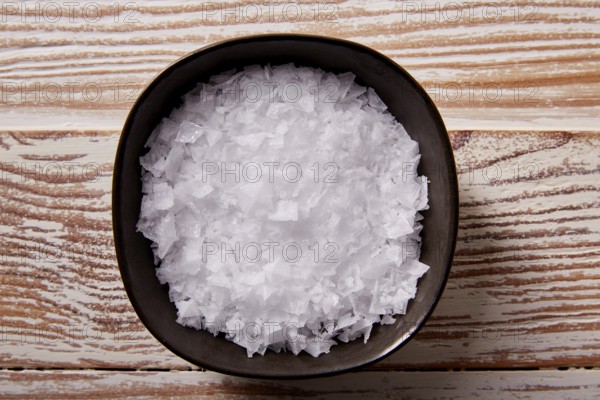 Maldon sea salt flakes in a bowl on a wooden board