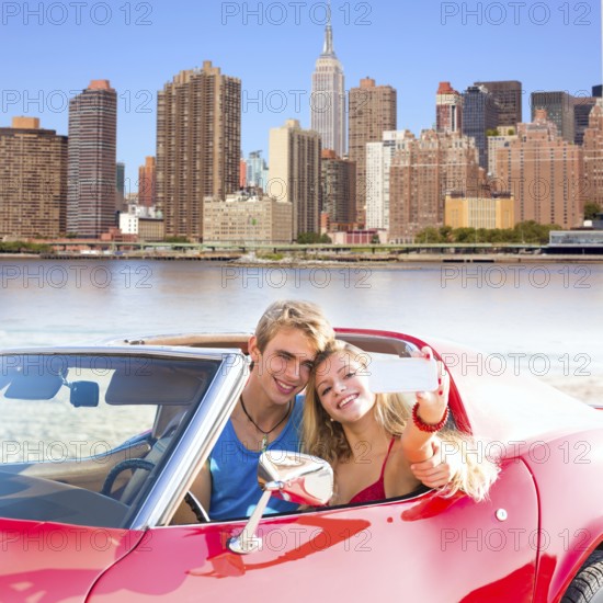 Selfie of young teen couple at convertible car in New York Manhattan skyline photo mount