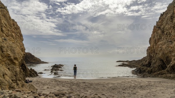 A picturesque small beach in a rocky cove with reef at low tide