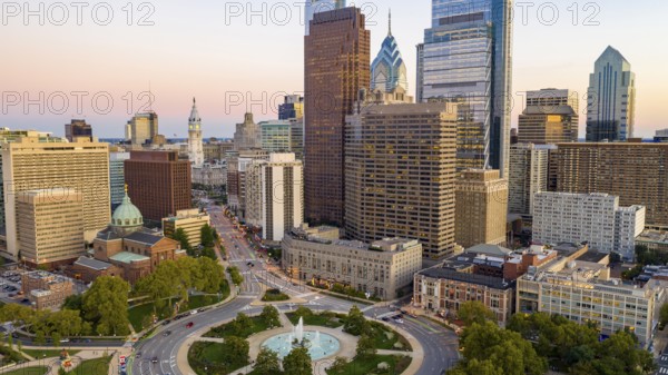 Vehilce traffic circles around the fountain at Logan Square in the bustling urban core of Philadelphia PA
