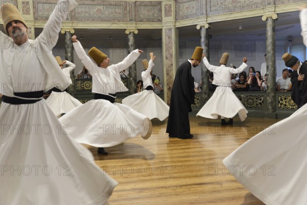 Dancing dervishes, Dervish dance Sema, Mevlevihanesi Müzesi at Istiklal Caddesi, Istanbul, European part, Turkey, Asia, A group of dervishes dances synchronously in white robes on a wooden floor surrounded by spectators, Istanbul province, Several dervishes turn in a traditional dance, Istanbul Modern, Asia