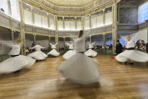 Dancing dervishes, dervish dance Sema, Mevlevihanesi Müzesi at Istiklal Caddesi, Istanbul, European part, Turkey, Asia, A group of dervishes dances synchronously in white robes on a wooden floor surrounded by spectators, Istanbul province, White robes in dynamic spinning movement embody the spiritual practice of the dervishes, Istanbul Modern, Asia
