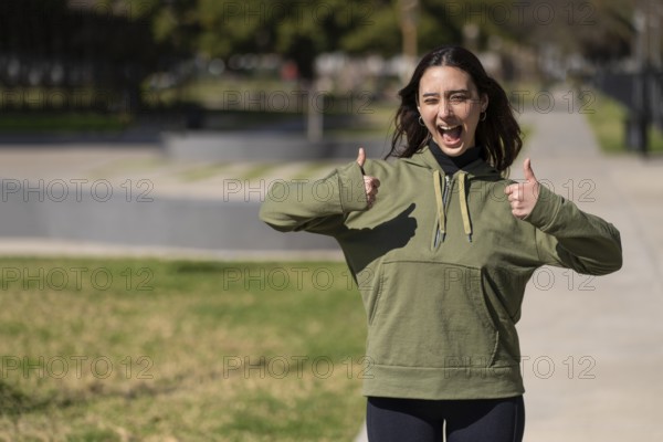 Young woman with happy expression and thumbs up