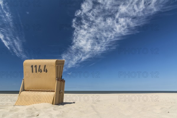 Lonely beach chair near the ocean under blue sky