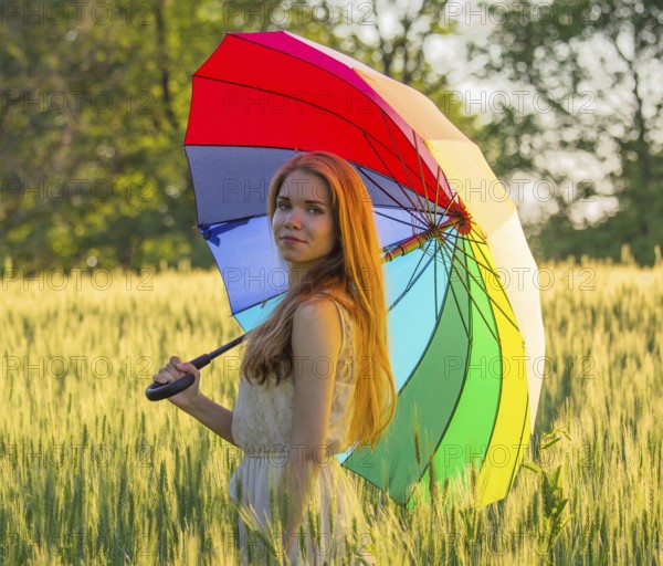 Portrait of a cute girl with a multicolored umbrella