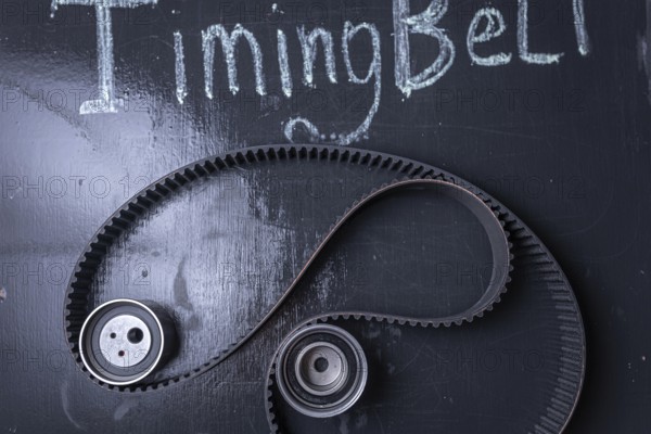Timing belt on a blackboard with chalk writing and gears