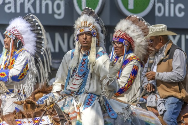 Calgary, Alberta, Canada. July 7, 2023. Close up to a First Nations people wearing traditional cloths while riding horses at a public festival parade