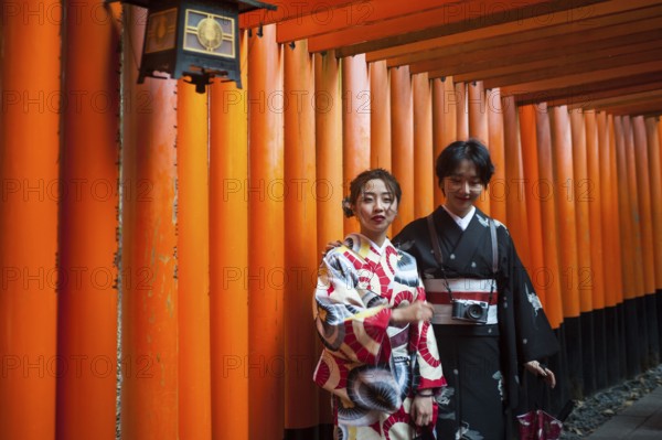 24.12.2017, Kyoto, Japan, Asia, Two young Japanese women stand in one of the torii pathways leading to Fushimi Inari-Taisha, a Shinto shrine in the Fushimi district of Kyoto city, Asia
