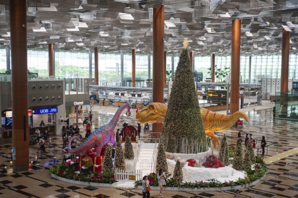 08.12.2020, Singapore, Republic of Singapore, Asia, dinosaurs, a sleigh and a Christmas tree serve as Christmas decorations and photo backdrop in Dino Wanderland for visitors and air travellers in the departure hall in Terminal 3 of Changi International Airport amid the global coronavirus (Covid-19) pandemic, Asia
