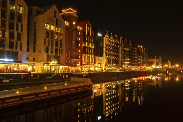 Old town in Gdansk at night. The riverside on Granary Island reflection in Moltawa River Cityscape at twilight. Ancient crane at dusk. Visit Gdansk Poland Travel destination. Tourist attraction