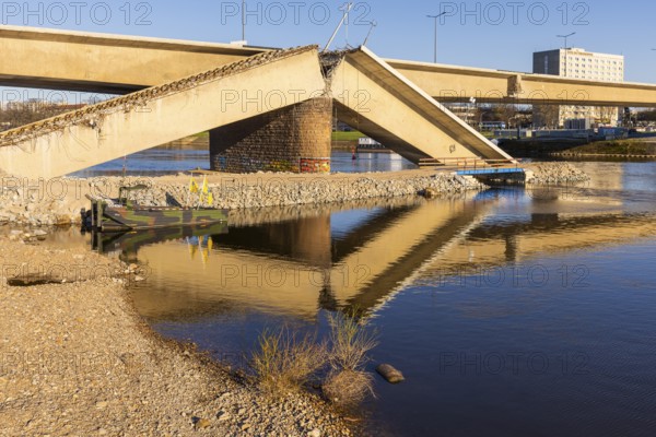 Following the partial collapse of the Carola Bridge, demolition work is being prepared. The construction road on the Neustädter Ufer had to be opened to improve water drainage, but a small temporary bridge still makes it passable for construction vehicles, Dresden, Saxony, Germany, Europe