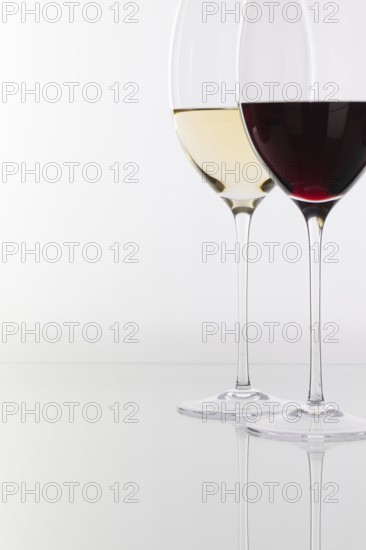 Wineglass with red and white wine on a glass table