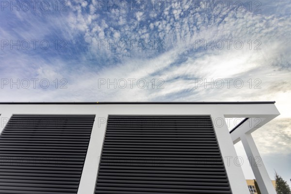 An intriguing and striking perspective captured of a buildings roof featuring unique lines set against a dynamic sky