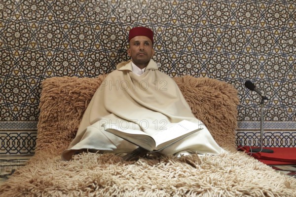 Rabat, Morocco - 29 November 2018: Koran reader sits in The Mausoleum of Mohammed V which is a mausoleum located on the opposite side of the Hassan Tower, on the Yacoub al-Mansour esplanade in Rabat, Morocco, Africa