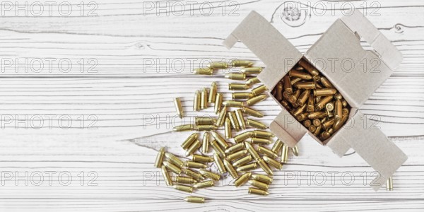 Top down view, carton box with yellow brass ammunition bullets on white wooden desk, banner - space for text left side, Liptovsky Mikulas, Slovakia, Europe