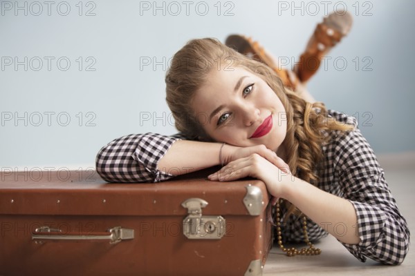 Beautiful pin up girl. Portrait of a beautiful retro woman. Girl with an old suitcase