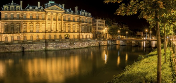 Night panoramic view with the Rohan Palace and the river Ill, with building and yellow lights reflected in its water