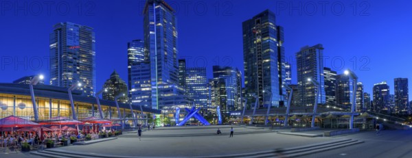 Night view of a modern city with illuminated skyscrapers and a sculpture in the centre, Vancouver, British Columbia, Canada, North America
