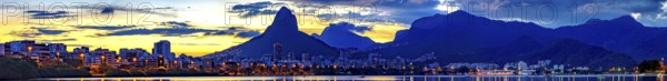 Panoramic image of summer sunset seen from the lagoon Rodrigo de Freitas with the buildings of the city of Rio de Janeiro, Two Brothers hill and Gavea stone