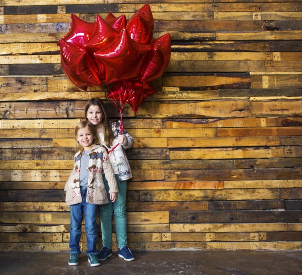 Children with balloons at wooden wall