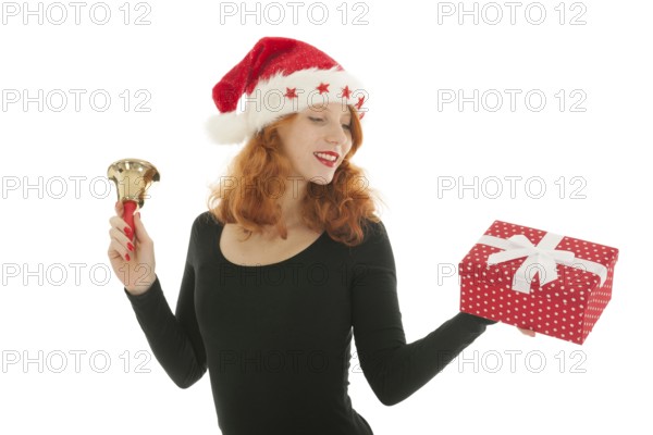 Young red haired woman with Christmas gift and bell of Santa Claus