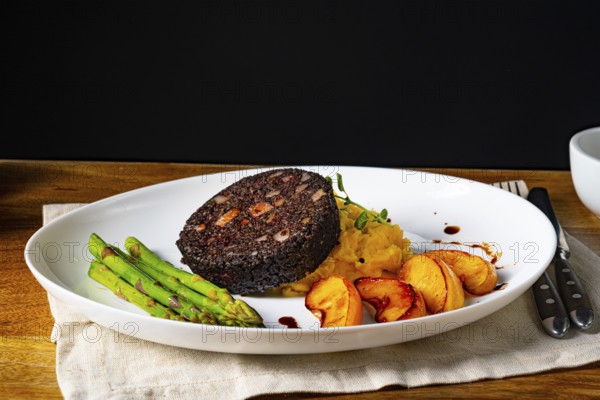 Black pudding with green asparagus and roasted apple