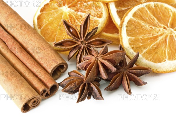Cinnamon sticks, anise stars and orange slices on white background Cinnamon sticks, anise stars and orange slices on white background