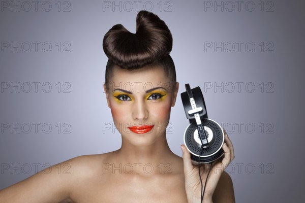 A beautiful photo of a beautiful girl holding headphones in her hand