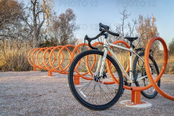 Touring bike parked in colorful helix bike racks along a trail in Fort Collins, Colorado - outdoor activity and bike commuting concept