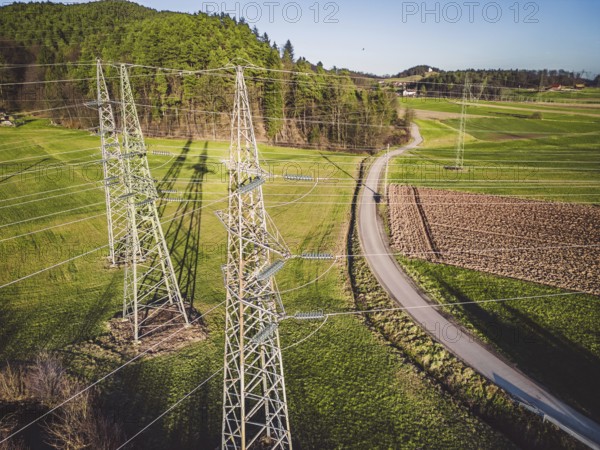 Electrical power substation in the country side of Slovenia. Fields and forests surrounding the power station in the suburbs. Aerial view