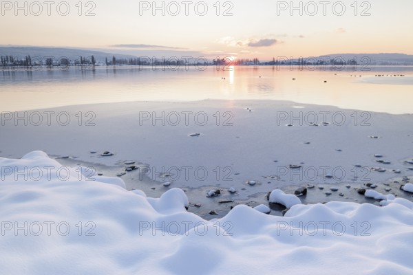 Snow-covered shores of a frozen lake at sunset, quiet and peaceful atmosphere, Seegarten, Allensbach, Lake Constance, Baden-Württemberg, Germany, Europe