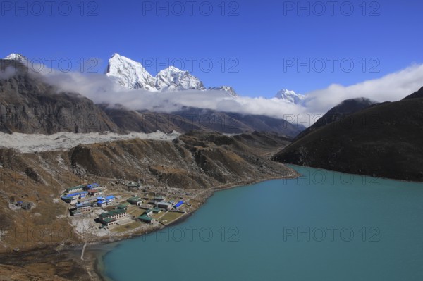 Gokyo, turquoise lake, Ngozumpa Glacier and snow covered mountain Cholatse, Nepal, Asia