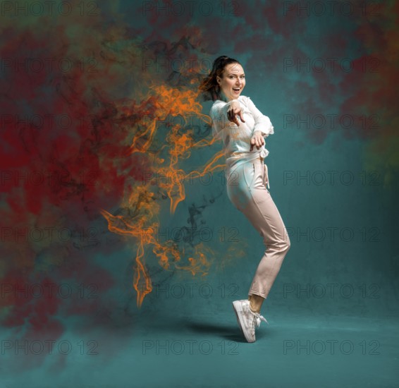 Young and beautiful dancer posing in the studio in front of a colourful background